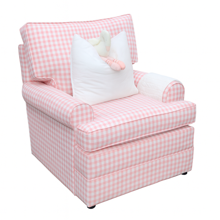 A plush nursery armchair named the Jetaime Chair, upholstered in soft pink and white gingham fabric. The chair features rolled arms, a cushioned seat and backrest, a white pillow with a stuffed toy, and a quilted armrest cover, creating a cozy and charming look.