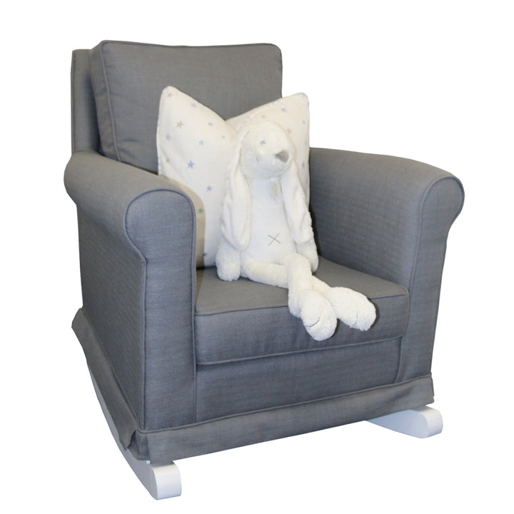 Tres Chic Rocking Chair in charcoal grey fabric with white wooden rocking legs, styled with a star-print cushion and plush bunny toy.